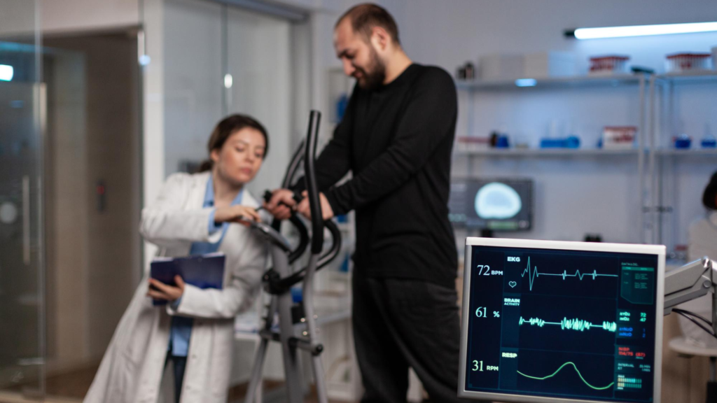 man exercising on rehabilitation equipment while a doctor adjusts the device